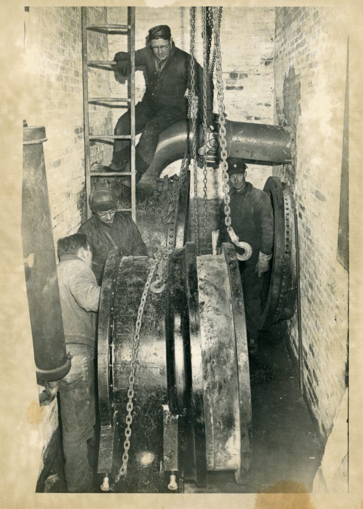 Photo of employees working on a 48-inch waste gate in the 1970s.